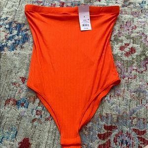 orangey red body suit